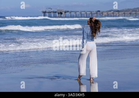 Atemberaubende Frau sonnt sich in der Nähe eines Piers, unter klarem blauem Himmel und genießt die Ruhe eines perfekten Tages am Meer, La Jolla, United Sta Stockfoto