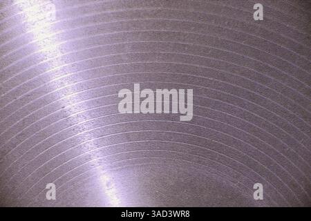 Licht reflektiert auf einer strukturierten violetten Oberfläche und erzeugt konzentrische Kreise, was auf Tiefe und Bewegung hindeutet. Weißrussland Stockfoto