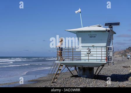 Atemberaubende Frau sonnt sich in der Nähe eines Piers, unter klarem blauem Himmel und genießt die Ruhe eines perfekten Tages am Meer, La Jolla, United Sta Stockfoto