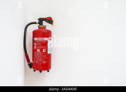 Feuerlöscher im Treppenhaus des Gebäudes. Wandmontierter florinfreier Schaumlöscher mit Quetschgriff, der an der weißen Wand hängt. Luzern, Switzer Stockfoto