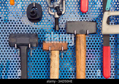 Sammlung von Hammerwerkzeugen an Bord in der Garage Stockfoto
