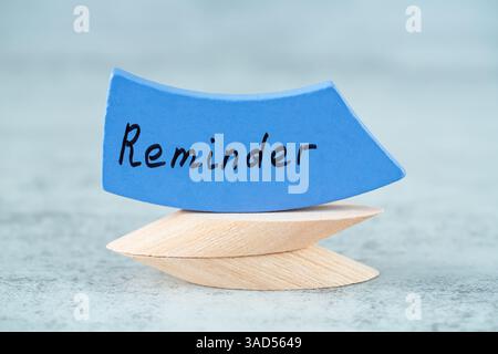 Erinnerungswort mit schwarzen Buchstaben auf dem blauen Holzbrett auf grauem Hintergrund. Motivationswort. Stockfoto