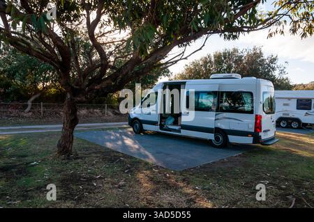 Maui Campervan parkte auf dem Campingplatz, Outdoor-Abenteuer, Mietmobil unter Bäumen, sonniger Tag, Pambula Beach, Australien Stockfoto