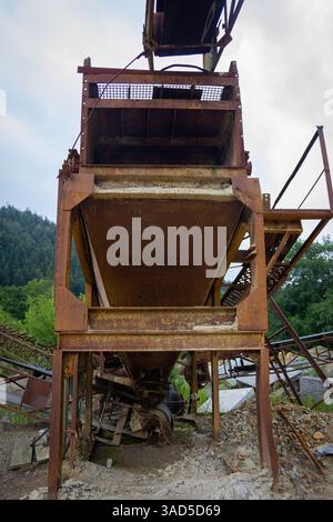 Eine große, verrostete Metallkonstruktion mit einem Loch in der Mitte. Die Struktur scheint ein Förderband zu sein, und das Loch in der Mitte ist wahrscheinlich eine Lüftung Stockfoto