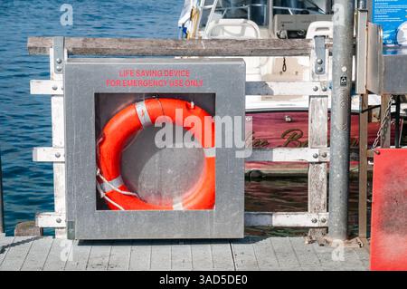 Lebensrettende Ringboje in der Notfallbox am Yachthafen Dock, Sicherheitsausrüstung am Wasser, sonniger Tag, Merimbula, Australien Stockfoto