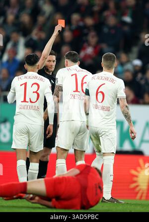 AUGSBURG, DEUTSCHLAND - 04. APRIL: Schiedsrichter Matthias Jöllenbeck zeigt beim Bundesliga-Spiel zwischen dem FC Augsburg und dem FC Bayern München in der WWK-Arena am 04. April 2025 in Augsburg die gelbe rote Karte Kristijan Jakic vom FC Augsburg. © diebilderwelt / Alamy Stock Stockfoto