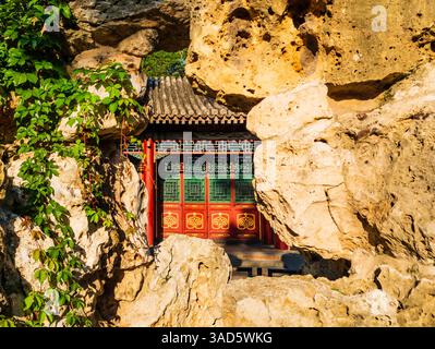 Ein eindrucksvoller Blick auf das alte Yu Lan Tang Gebäude durch die Felsen des traditionellen botanischen Gartens im Sommerpalast, Peking, China Stockfoto