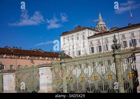 Blick auf den Königspalast von Turin (Palazzo reale) und die Piazza Castello in Turin, Italien, mit ihrer beeindruckenden Fassade und den kunstvollen Toren unter einem Blau Stockfoto