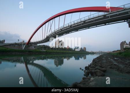 Ein Blick auf Taipeis Rainbow Bridge in der Dämmerung, eine Fußgängerbrücke, die den Keelung River in Taiwan überspannt. Stockfoto