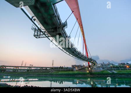 Ein Blick auf Taipeis Rainbow Bridge in der Dämmerung, eine Fußgängerbrücke, die den Keelung River in Taiwan überspannt. Stockfoto