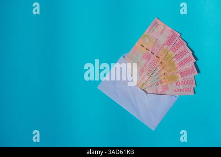 Indonesische Banknoten in einem Umschlag, die Geldgeschenke oder Zahlungen symbolisieren, ideal für Finanz-, Geschenk- oder transaktionsbezogene Themen Stockfoto