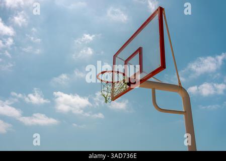 Orangener Basketballkorb im Freien mit blauem Wolkenhimmel. Hochwertige Fotos Stockfoto