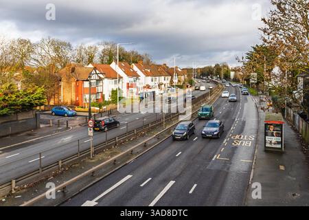 Befahrene Vorstadtstraße mit Verkehr und Wohnhäusern. London, UK, 31. Dezember 2023 Stockfoto