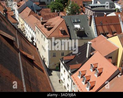 Blick aus der Vogelperspektive auf eine malerische europäische Stadt mit roten Ziegeldächern, die eine Mischung aus Wohnhäusern und engen Gassen zeigt. Die Szene fängt den Charme ein Stockfoto