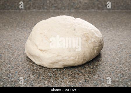 Brotteig auf der Küchentheke. Rohes, geknetes Hefebrot, das auf dem Tisch liegt. Bereit für den ersten Aufstieg. Traditionelles Schweizer Butterbrot-Rezept namens Zopf oder B Stockfoto