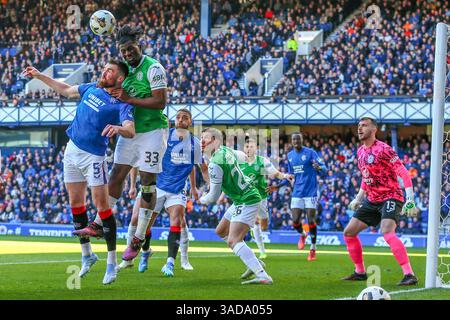 April 2025. Glasgow, Großbritannien. Rangers FC spielte Hibernian FC im Ibrox Stadium, Glasgow, dem Heimstadion der Rangers, in einem Spiel der William Hill Premiership. Das Endresultat waren die Rangers FC 0:2 Hibernian FC. John Souttar (r5) und Rocky Bushiri (H33) treten in der Hibernischen Torhülle um den Ball an. Quelle: Findlay / Alamy Live News Stockfoto