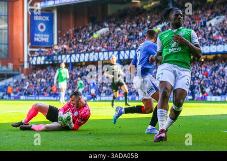 April 2025. Glasgow, Großbritannien. Rangers FC spielte Hibernian FC im Ibrox Stadium, Glasgow, dem Heimstadion der Rangers, in einem Spiel der William Hill Premiership. Das Endresultat waren die Rangers FC 0:2 Hibernian FC. Cyriel Dessers (R9) versucht zu schießen und wird von Rocky Bushiri (H33) angegriffen und der Ball wird von Jordan Smith, dem Hibernischen Torhüter Credit: Findlay / Alamy Live News, gerettet Stockfoto