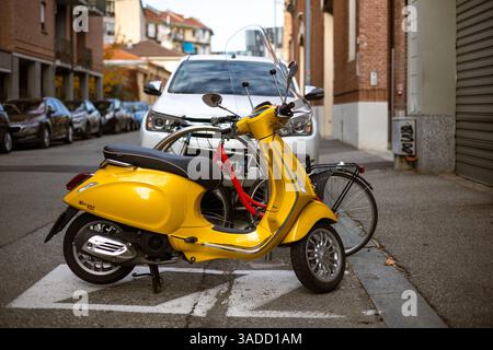 Turin, Italien - 08. November 2021: Ein gelber Vespa Primavera Sprint 125, Roller mit Windschutzscheibe auf einem ausgewiesenen Parkplatz auf einer Stadtstraße, mit Stockfoto