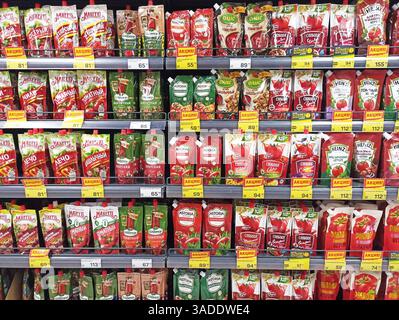 Aktau, Kasachstan - 22. März 2025: Verschiedene Tomatenprodukte im Supermarktregal mit angezeigten Preisen. Stockfoto