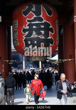 2. April 2000; Tokio, Japan; Eine Frau und ein Kind werden von einem dekorativen japanischen Objekt auf dem Gelände des Senso-JI-Tempels in Tokio im Stadtteil Asakusa in Tokio im Schatten gehalten. (Bild: Barry Cronin/ZUMAPRESS.com) Stockfoto