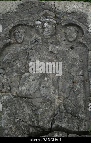 September 2005; Thomastown, Co Kilkenny, Irland; im Jahr 1203 zogen sich die Knights of Jerpoint von den Kreuzzügen zurück und kehrten nach Irland zurück. Auf dem Weg entfernten sie den Leichnam des Heiligen Nikolaus aus seinem Grab in Myra, in der heutigen Türkei, und legten ihn zur Ruhe in der Kirche St. Nikolaus, die etwa eine Meile von ihrer Abtei in Jerpoint entfernt war. Das ist derselbe Mann, der die Praxis, den Armen Geschenke zu geben, ihm schließlich den bekannteren Titel "Weihnachtsmann" einbringen würde. Diese Felsplatte, auf der das Bild eines Mönchs und zweier Helfer zu sehen ist, markiert sein Grab. Stockfoto