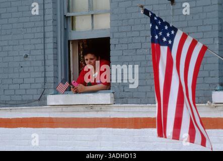 Juni 1991; Newburgh, NY, USA; Zuschauer beobachten eine Military Appreciation Parade, die die Sterne und Streifen der amerikanischen Flagge in Newburgh, NY, winkt. Die Parade fand statt, nachdem US-Truppen nach dem Golfkrieg gegen den Irak nach Hause kamen. (Bild: Jack Kurtz/ZUMAPRESS.com) Stockfoto