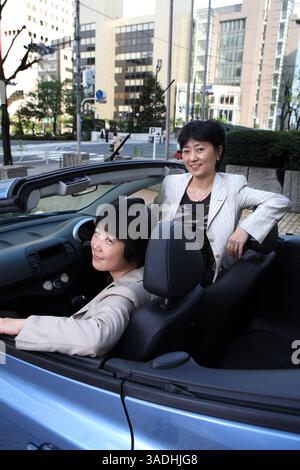 April 2008 – Tokio, Japan – weibliche Manager und Führungskräfte von Nissan, MIYUKI TAKAHASHI, aÊGeneral Manager für das Büro DiversityÊDevelopment, im Vordergrund und ASAKO HOSHINO, Corporate Vice President für Market Intelligence Department, sitzen im Nissan Micra C+C Seat That wasÊdisplayed vor dem Nissan HQ Showroom in Ginza, Tokio (Credit Image: Ko Sasak/ZUMAPRESS.com) Stockfoto