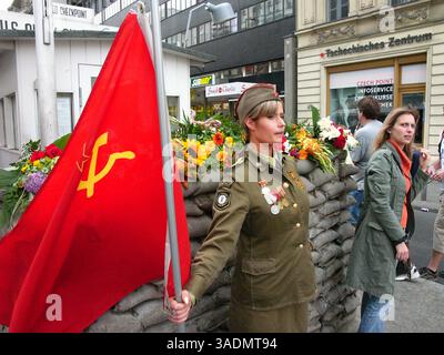 3. September 2005; Berlin, DEUTSCHLAND; Ein Modell in sowjetischer Uniform hält am Berliner Checkpoint Charlie eine sowjetische Flagge. Der Kontrollpunkt befand sich im alten US-Sektor in West-Berlin und war der letzte der drei Kontrollpunkte in West-Berlin, die man nutzen konnte, um nach Ost-Berlin zu gelangen. . (Kreditbild: Bill Putnam/ZUMAPRESS.com) Stockfoto