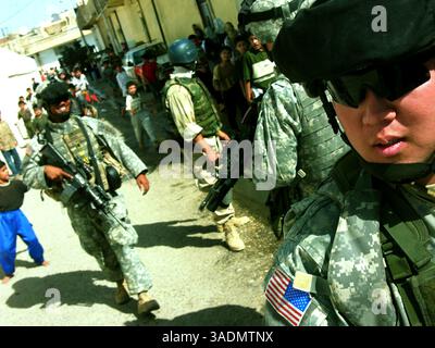 10. Oktober 2005; Mossul, IRAK; First Lt. James Kwon, ein Zugführer in Kompanie C, 2. Bataillon, 1. Infanterieregiment, und seine Patrouille werden von einer Menge irakischer Kinder verfolgt, nachdem sie eine Schule verlassen haben, die zum Wahllokal umgebaut wurde 2005. Viele Schulen in Mossul wurden in der Woche vor dem 15. Oktober 2005 geschlossen und die irakische Armee und Polizei besetzten die Stätten. (Kreditbild: Bill Putnam/ZUMAPRESS.com) Stockfoto