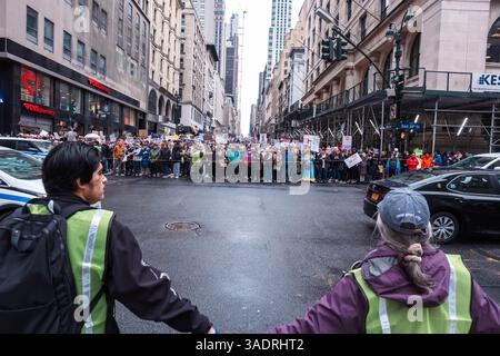Protestveranstalter halten Demonstranten zurück, damit der Verkehr durch die Kreuzung an der 34. Straße und der Fifth Avenue fährt. Trotz des Regens versammeln sich Tausende von Demonstranten im Bryant Park und marschieren im Rahmen einer landesweiten Anti-Trump-Kundgebung zum Madison Square Park. Mehr als 1200 Städte und Städte sind beteiligt, aber auch einige im Ausland. Der Protest wurde von einer Koalition mehrerer Interessengruppen organisiert, darunter The Invisible, MoveOn, 50501 Movement & Women's March. Die Demonstranten fordern „Hands Off“ Gesundheitsfürsorge, soziale Sicherheit, Bildung und protestieren gegen Probleme, die die Gesundheit von Frauen bedrohen Stockfoto