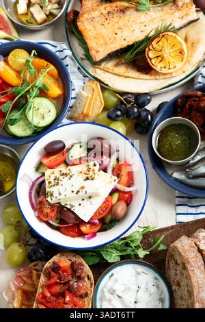 Griechische Küche Hintergrund. FSH, Pita, griechischer Salat, Tzatziki, Feta, Oliven. Traditionelle griechische Gerichte auf hellem Hintergrund. Draufsicht. Stockfoto