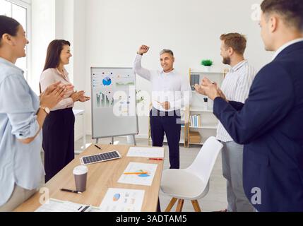 Ein Team aus glücklichen Menschen feiert Geschäftserfolg und Führung, applaudiert und Spaß hat Stockfoto