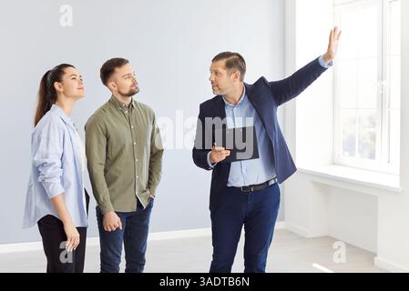 Immobilienmakler zeigt einem Paar ein Haus, Nahaufnahme Stockfoto