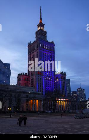 Warschau, Polen. Januar 2025 - Palast der Kultur und Wissenschaft beleuchtet mit bunten Lichtern am Abend. Stockfoto