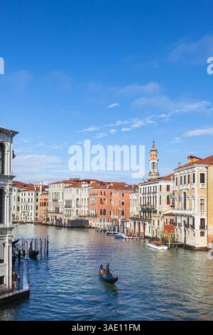 Gondoliere, die Touristen an einem sonnigen Wintermorgen auf dem Canale Grande von Venedig mitnehmen, von der Rialto-Brücke aus gesehen, Stockfoto