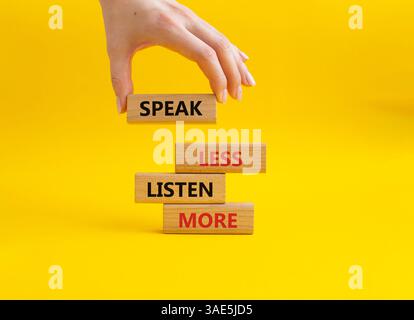 Weniger sagen, mehr hören. Holzblöcke mit Wörtern sprechen weniger Hören Sie mehr. Schöner gelber Hintergrund. Geschäftsmann Hand. Geschäftlich und weniger sprechen Stockfoto