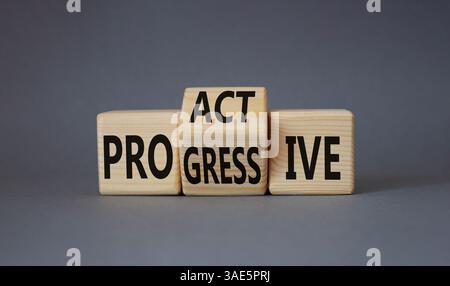 Symbol „Proactive“ und „Progressive“. Gedrehte Holzwürfel mit den Worten Progressive und Proactive. Schöner grauer Hintergrund. Geschäftskonzept. Kopierbereich Stockfoto
