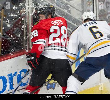 18. Januar 2012: Chicago, IL. Blackhawk Ben Smith #28 wird von Sabre Mike Weber #6 während des NHL-Spiels zwischen den Chicago Blackhawks und den Buffalo Sabres im United Center in Chicago, IL, in die Bretter eingecheckt. (Bild: © Mike Wulf/Cal Sport Media/ZUMAPRESS.com) Stockfoto