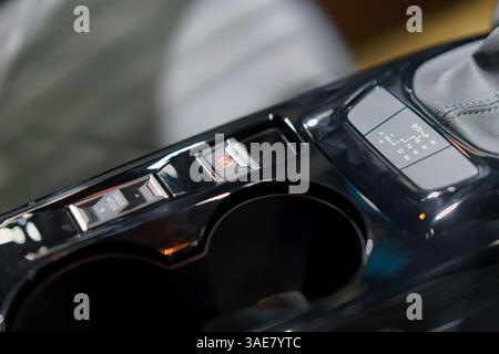 Moderne Fahrzeugkonsole mit elektronischer Feststellbremse, Fahrmodus-Taste und Schaltsteuerung für Komfort und Stil. Stockfoto