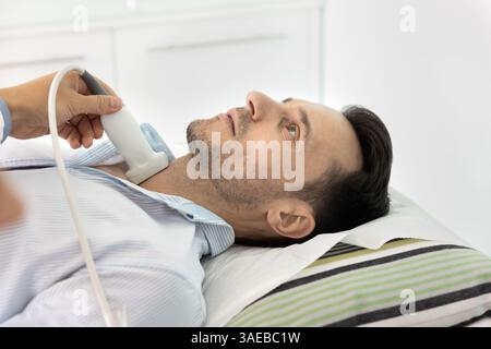 Auf dem Untersuchungstisch liegender Mann während des Ultraschallverfahrens. Stockfoto