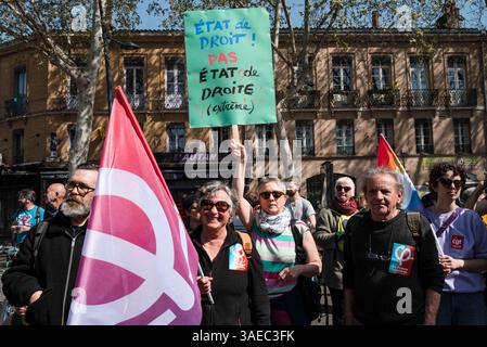 Toulouse, Frankreich. April 2025. LFI-Aktivisten mit Flagge und Plakat, Rechtsstaatlichkeit! Nicht rechtsextremer Zustand. Die linke Gegendemonstration, die von LFI und den Ökologen CGT gegen die RN-Demonstration für Marine Le Pen am 6. April 2025 in Toulouse, Frankreich, aufgerufen wurde. Foto: Patricia Huchot-Boissier/ABACAPRESS. COM Credit: Abaca Press/Alamy Live News Stockfoto