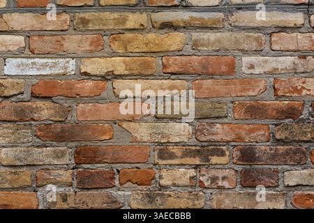 Alte Ziegelmauer. Geometrischer Hintergrund von mehrfarbigen Ziegeln. Mauerwerk. Stockfoto