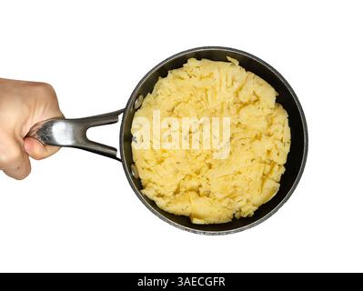 Kartoffelpüree mit Dill in der Pfanne, Blick von oben. Bratpfanne in der Hand des Mannes auf weißem isoliertem Hintergrund. Stockfoto