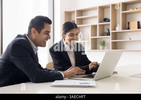 Zwei Arbeitskollegen, Profis, die mit einem Notebook zusammenarbeiten Stockfoto