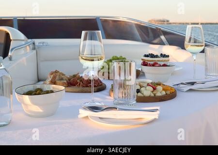 Erleben Sie ein Gourmet-Dining-Abenteuer auf einer luxuriösen Yacht, während Sie den Sonnenuntergang genießen Stockfoto