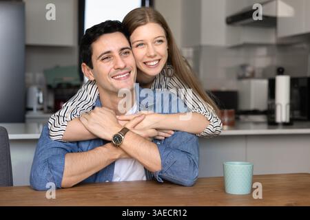 Wunderschönes junges Paar, das sich in der modernen Küche umarmt Stockfoto