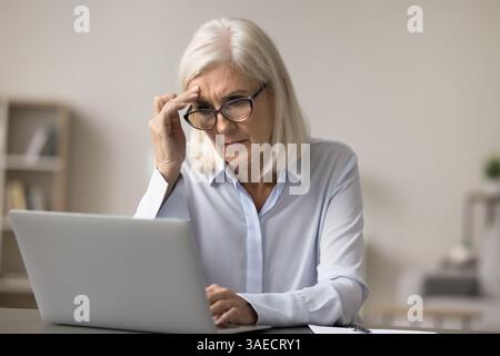 Besorgte Buchhalterin sitzt am Schreibtisch neben dem Notizbuch Stockfoto