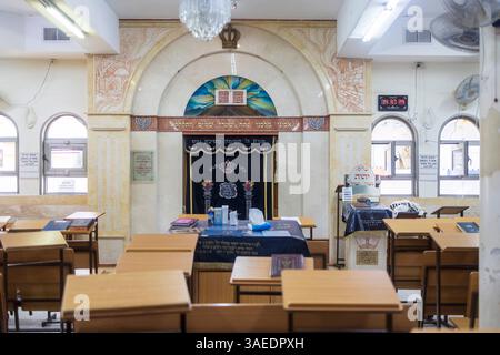 Haifa, Israel, 5. April 2025, Innenraum eines Tiferet Israel Jeshiva mit Holzschreibtischen, Bogenfenstern, hebräischen Inschriften und einer verzierten Tora Stockfoto