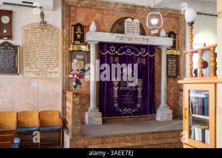 Haifa, Israel, 5. April 2025, Innenansicht einer Aram-Zzova-Synagoge mit einer dekorierten Toraarche mit hebräischen Inschriften, flankiert von Säulen und cov Stockfoto