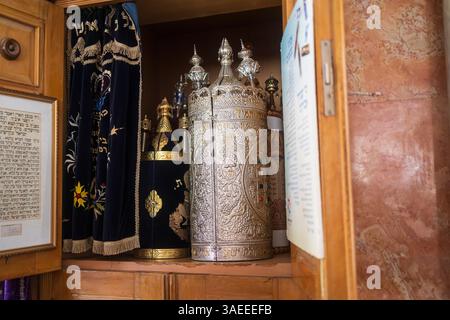 Haifa, Israel, 5. April 2025, Innenansicht einer Aram-Zzova-Synagoge. In der Nähe eines Holzschranks sind mehrere Sefer Tora-Schriftrollen mit Horn zu sehen Stockfoto